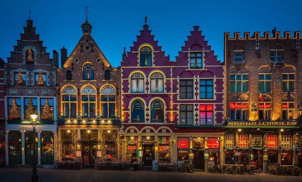 Travelling alone, old 19th century buildings dimly lit in Bruges