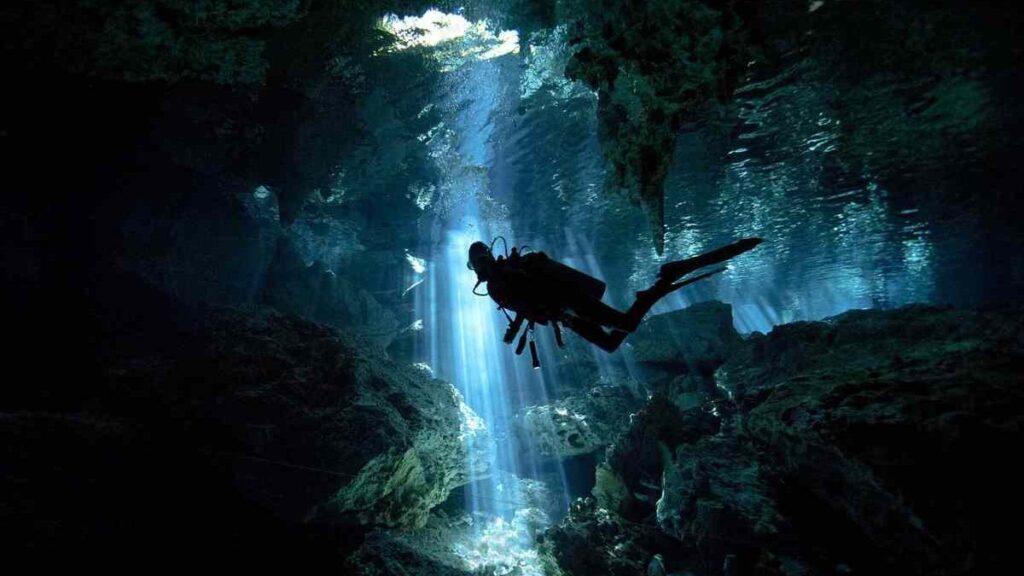 Scuba diver exploring a cave under water