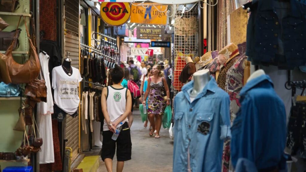 Personnes se promenant dans les chemins étroits du marché Chatuchak