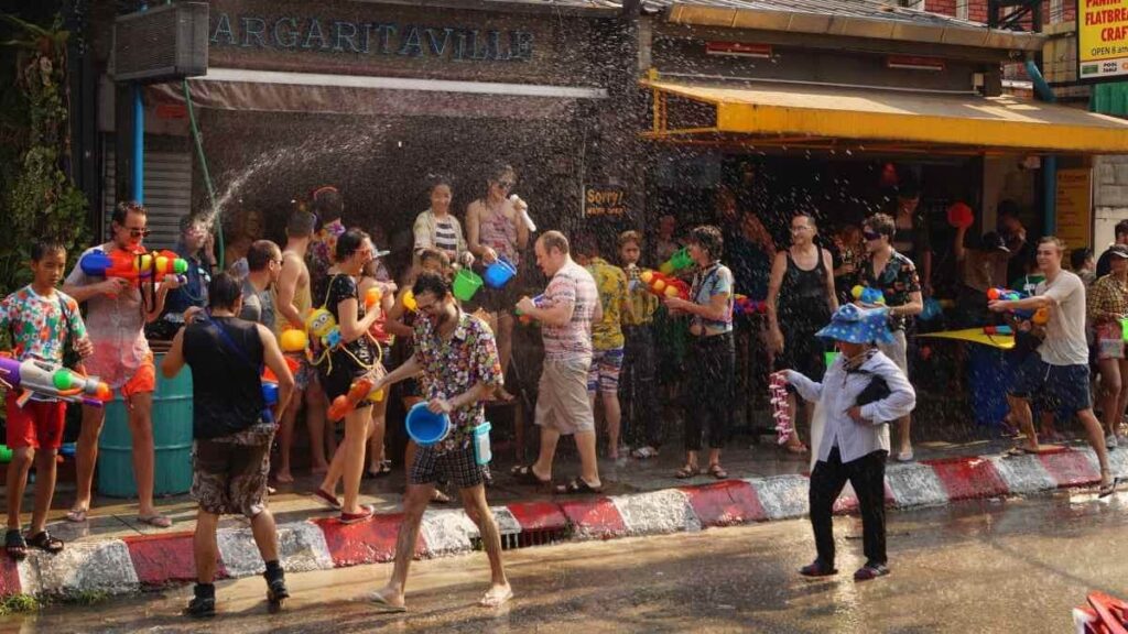 People in the streets of Thailand throwing water at each other to celebrate Songkran