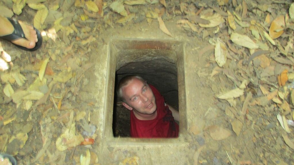 Travel Wanderlust co-founder Yann entering one of the famous Cu Chi tunnels